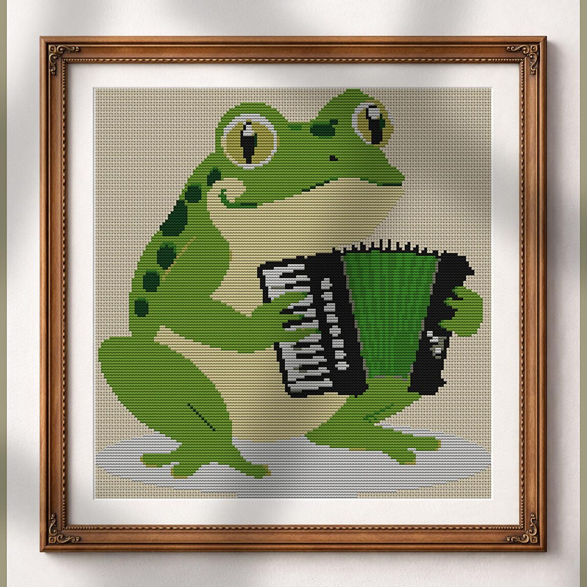 frog-playing-accordion alternative framed cross stitch mockup, realistic finished embroidery presentation